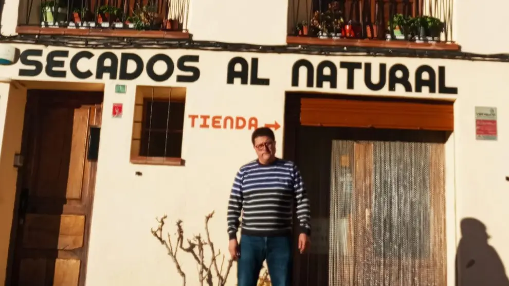 José Antonio Domingo en la fachada de la tienda Jamones El Rullo de Villarluengo.