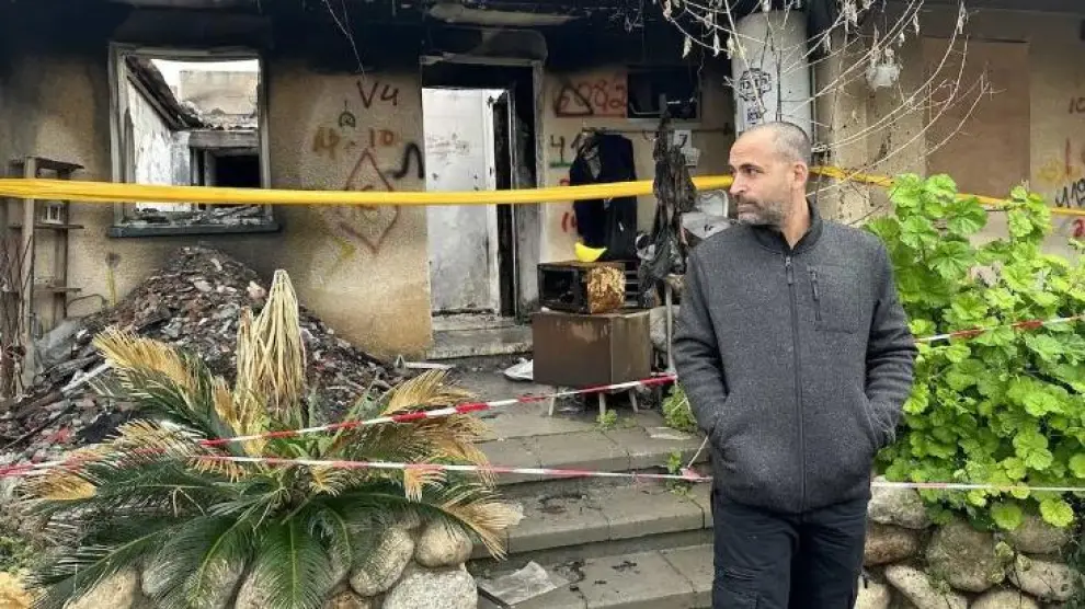 Avichai Brodutch, cuyo familiares fueron liberados durante el alto el fuego, ante una de las casas arrasadas por Hamás en Kfar Aza