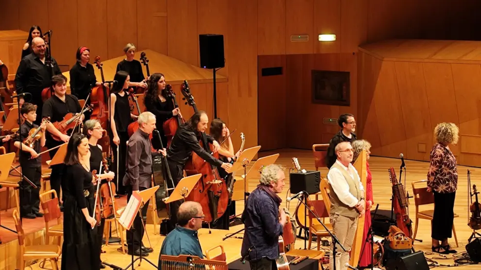 El quinteto O'Carolan saluda al público; detrás está el cuarteto Concuerda y la Orquesta de Cuerda de la Escuela de Música Municipal de Zaragoza.