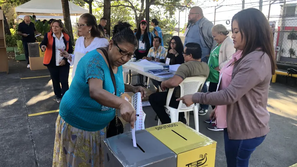 Una votante introduce su voto en la urna en colegio electoral Sagrado Corazón de San Salvador