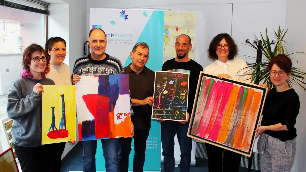 Miembros del Grupo de Creatividad de Huesca más inclusiva (organizador del festival) con las imágenes seleccionadas para votación popular .