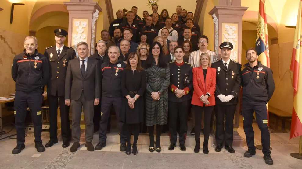 Foto de las autoridades con los galardonados y con componentes del parque de bomberos de Huesca.
