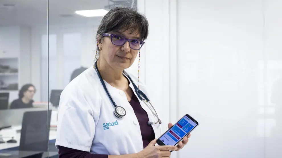 La doctora Amelia Cantarero muestra en su teléfono móvil la 'app' diseñada para mejorar la salud de los camioneros.