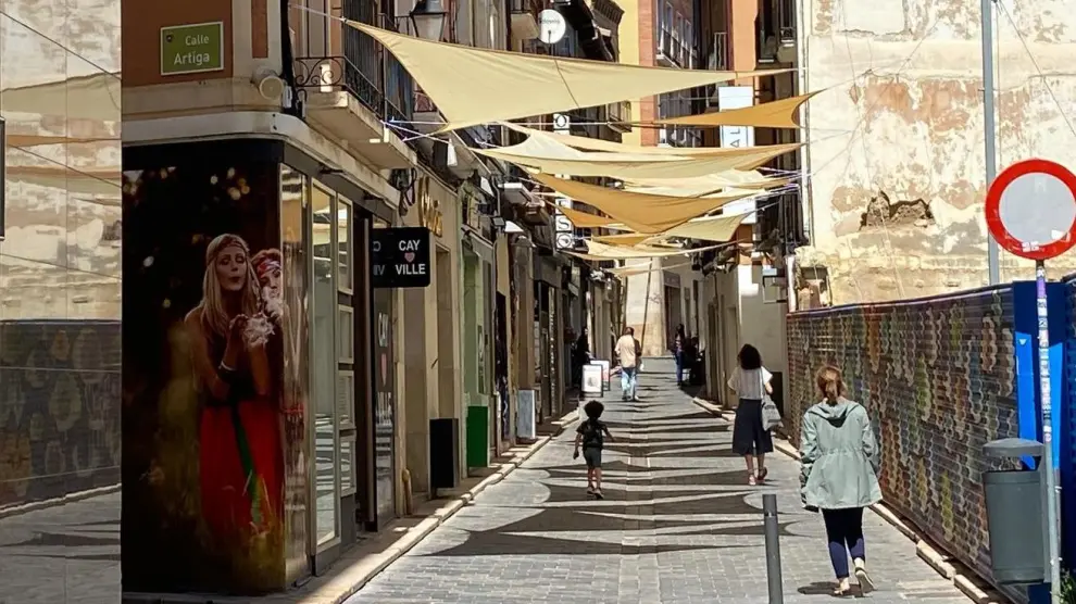 Velas de sombra en la calle la Correría de Huesca. A la derecha, el solar que lleva vacío 22 años.