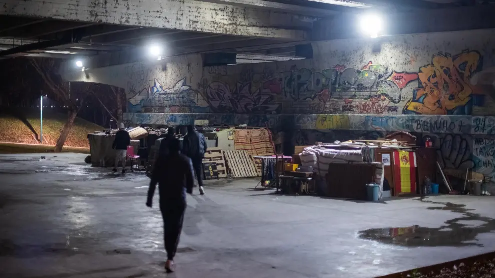 Varias personas sin hogar duermen bajo el puente de la Almozara en Zaragoza.