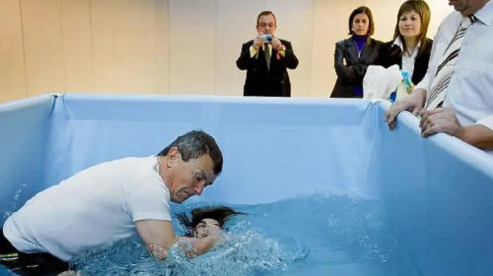 Liseth Jacome recibe el bautismo rodeada por otros Testigos de Jehová.