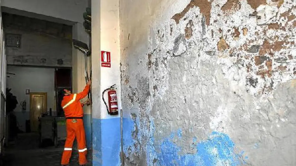 Las paredes del local destinado a los servicios de limpieza del ayuntamento están cubiertas de desconchones y humedades.