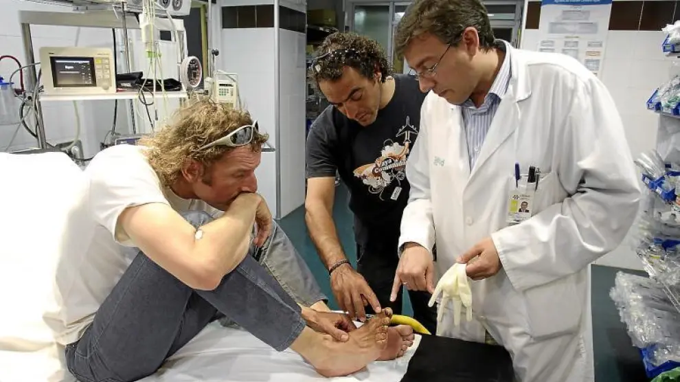 Javier Pérez (izquierda), Carlos Pauner (centro) y el cirujano Ismael Gil Romea, del Clínico, observan los dedos dañados del zaragozano.