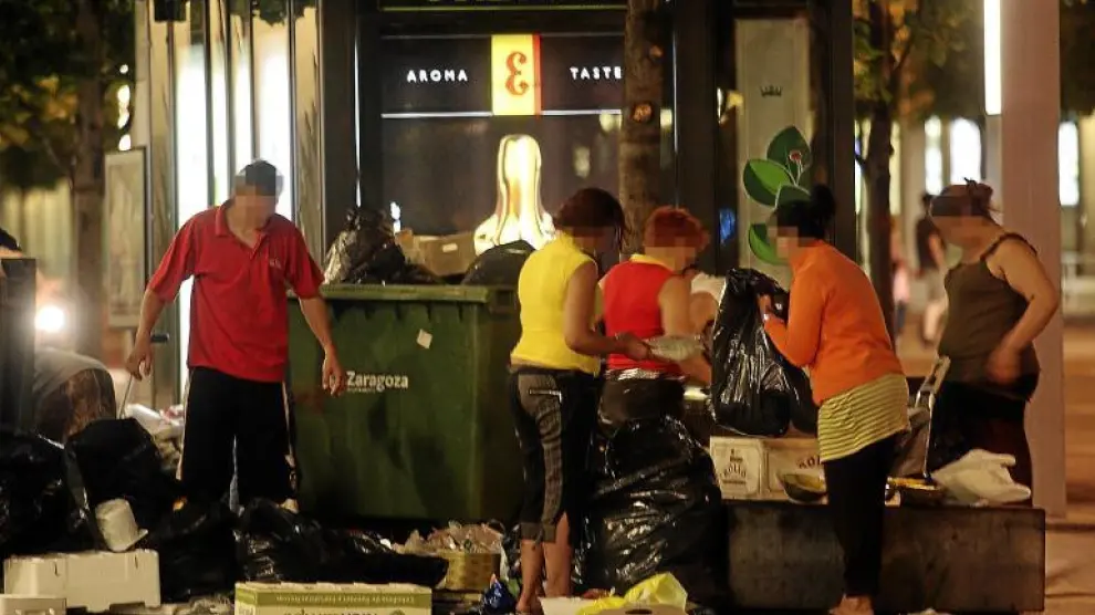 Una decena de inmigrantes se congregan cada noche en Independencia para buscar en la basura de los centros comerciales cercanos.