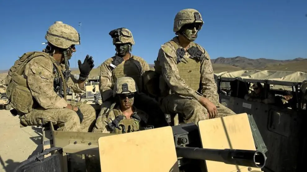 Marines estadounidenses, con pintura de camuflaje en sus caras, se preparan para salir de su base en Farah, ayer en Afganistán.
