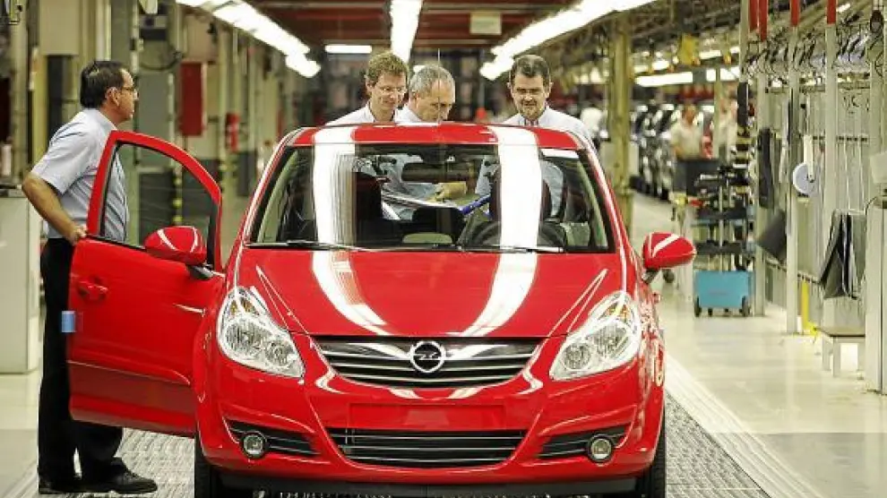 Operarios de la fábrica de Opel en Figueruelas comprueban uno de los vehículos de cadena.