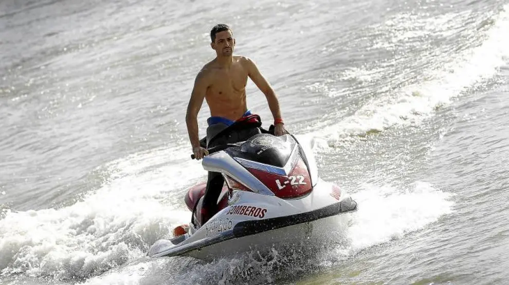 El bombero Alejandro Loire conduce una moto acuática en el posado que le tocó realizar ayer en el Ebro para el calendario de 2010.