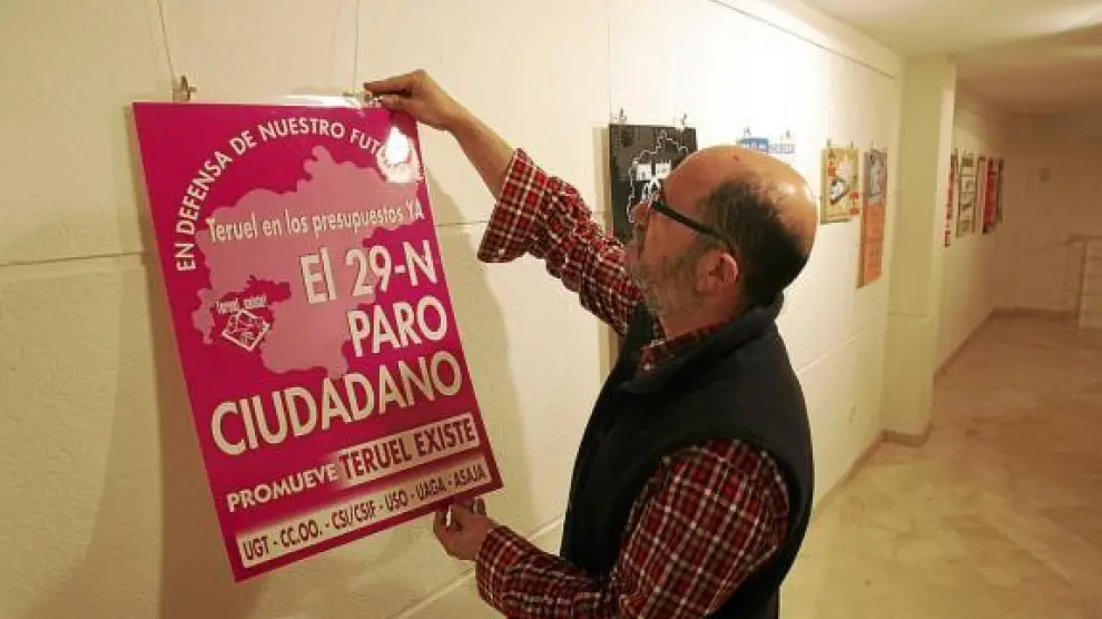 José Polo, de Teruel Existe, monta la exposición de carteles editados por la plataforma