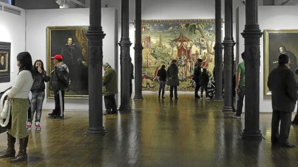 Sala del Paraninfo en la que comienza la exposición 'Selecta. Del Greco a Picasso', con el tapiz de la Manufactura Real de Beauvais 'El viaje del príncipe' al fondo