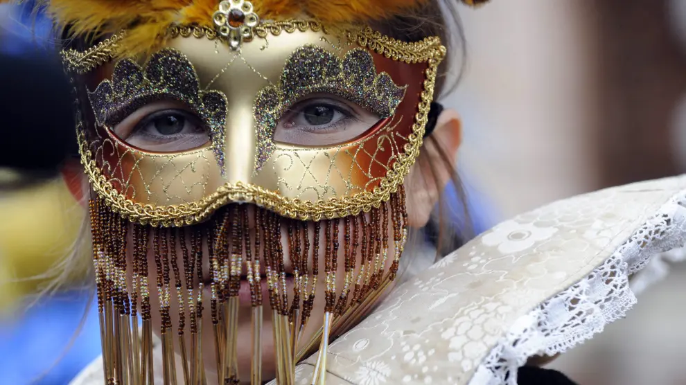 Una joven, ataviada con una delicada máscara de carnaval veneciana, en la plaza de San Marcos.
