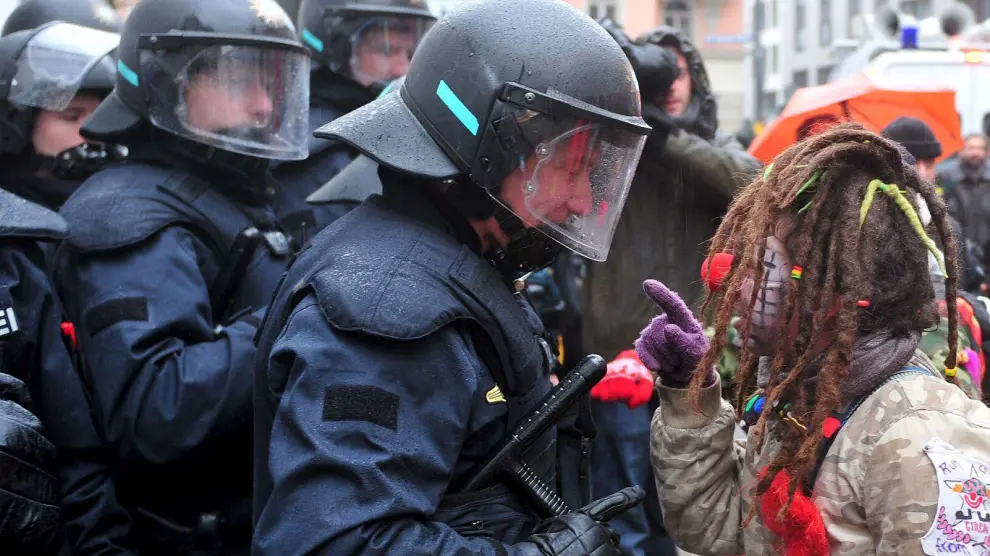 Una manifestante vestida de payasa regaña a un policía en una protesta contra la Conferencia de Seguridad, ayer en Múnich.