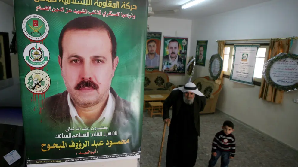 El padre y el nieto de Al Mabhuh pasan bajo un póster con su imagen en su casa de Jabalia, en el norte de la franja de Gaza, ayer