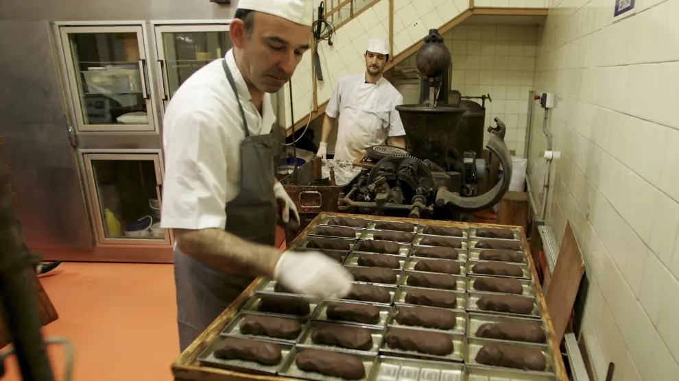 Algunos de los maestros pasteleros trabajan el chocolate en el obrador.
