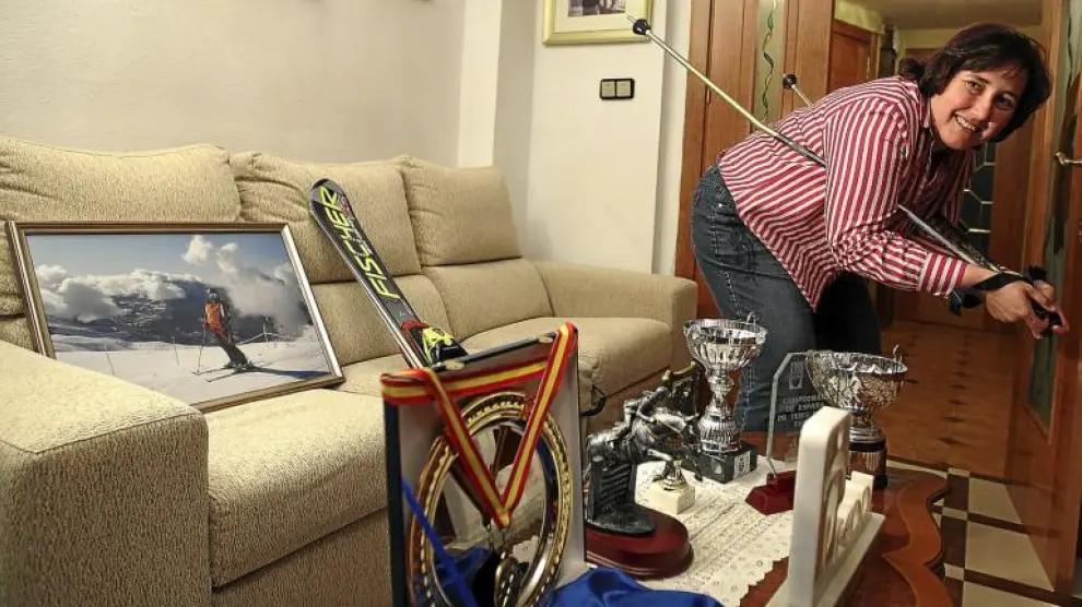 Beatriz, en el salón de su casa, con algunos de sus trofeos y parte de su equipación de esquí, de la que nunca se separa