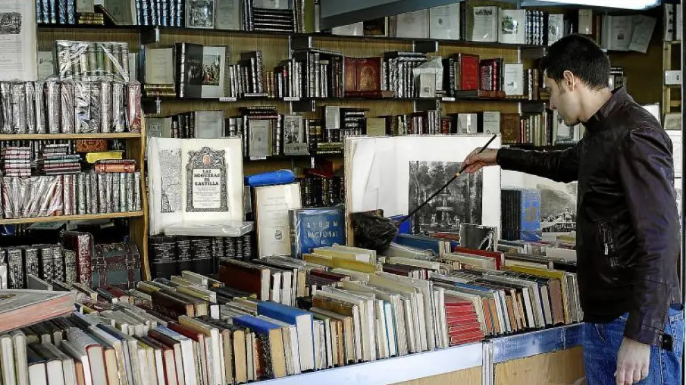 El librero José Javier García daba los últimos toques a su puesto en la Feria del Libro Viejo y Antiguo, que se abrió ayer.