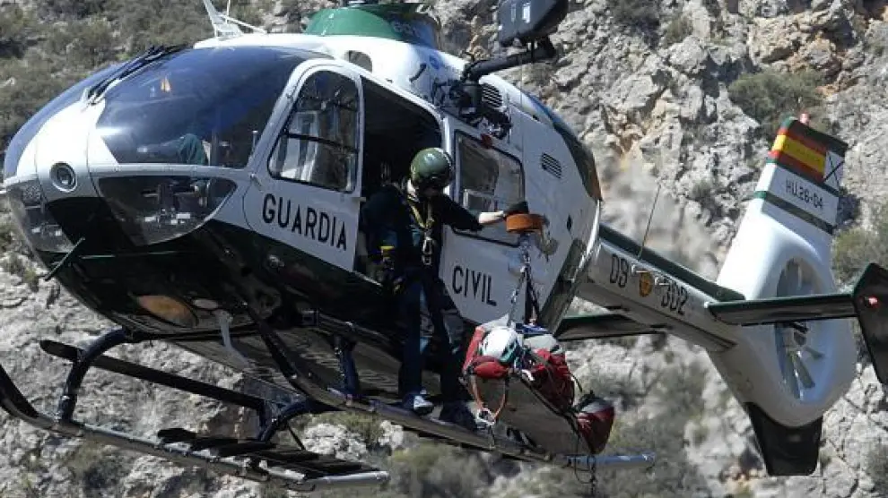 El herido, colocado en una camilla, fue evacuado en el helicóptero de la Guardia Civil.