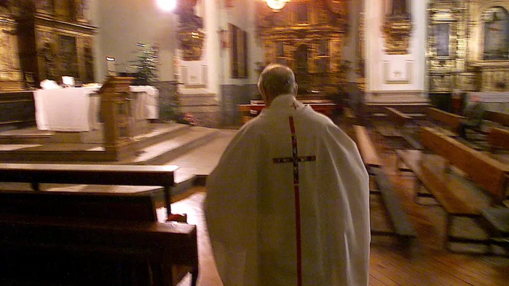 Un sacerdote sale a oficiar misa en una parroquia de Zaragoza