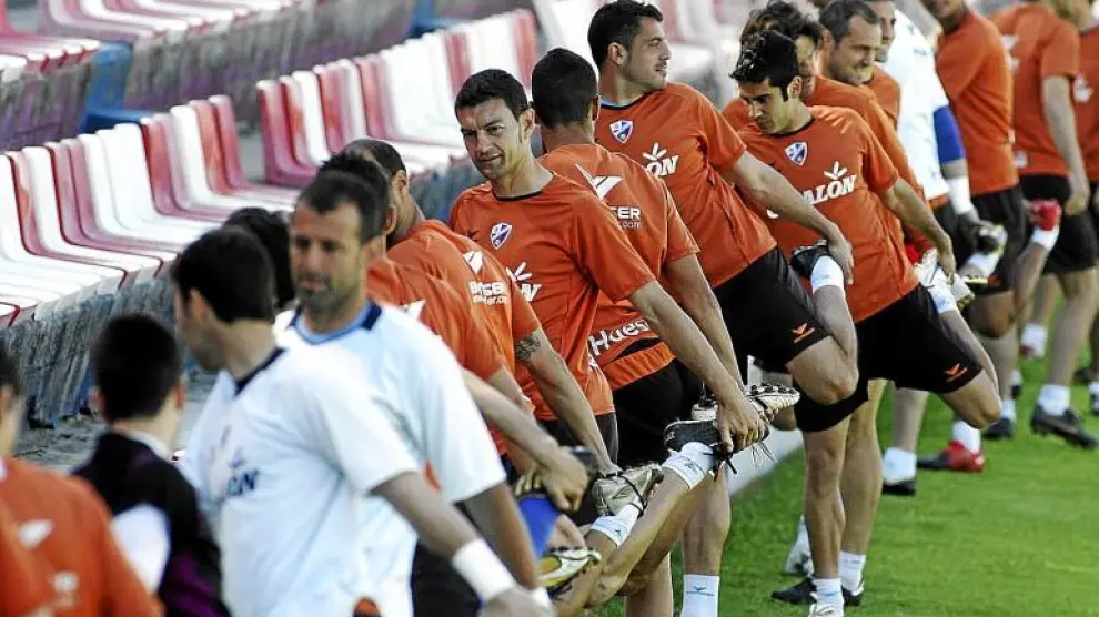 Los futbolistas del Huesca realizan estiramientos durante un entrenamiento en el estadio de El Alcoraz.