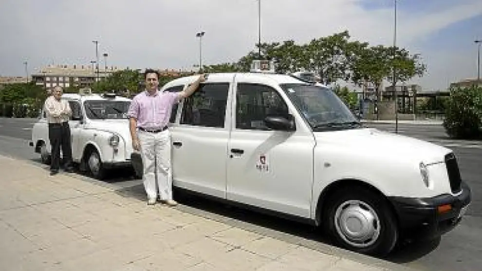 José Antonio Lahoz (derecha) y Carmelo Ruiz, con sus taxis.