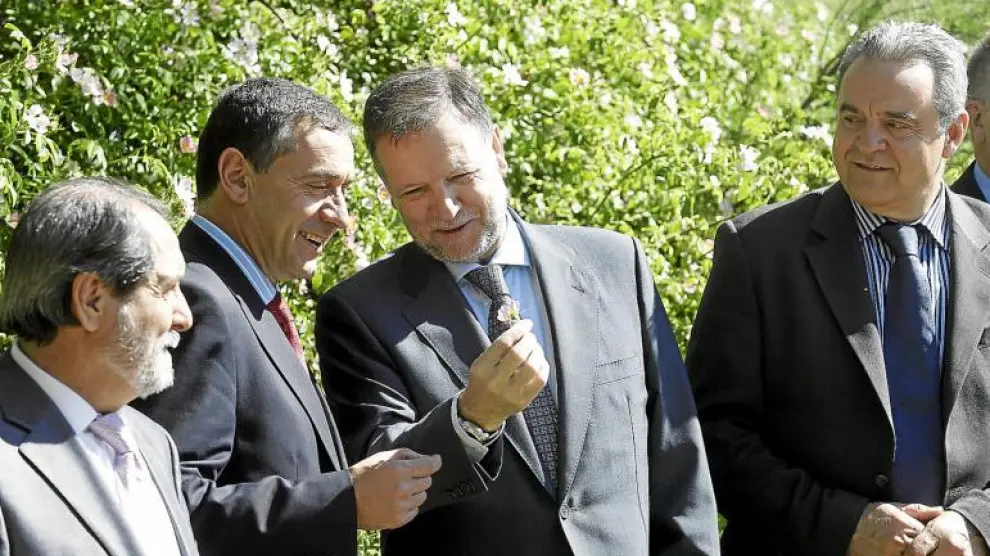 El presidente Iglesias bromea con el secretario de Estado y le muestra una flor, ante la atenta mirada de los consejeros Velasco y Boné.