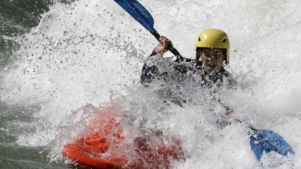 Uno de los participantes rotando con su embarcación en 'El paso de olas' del río Gállego.