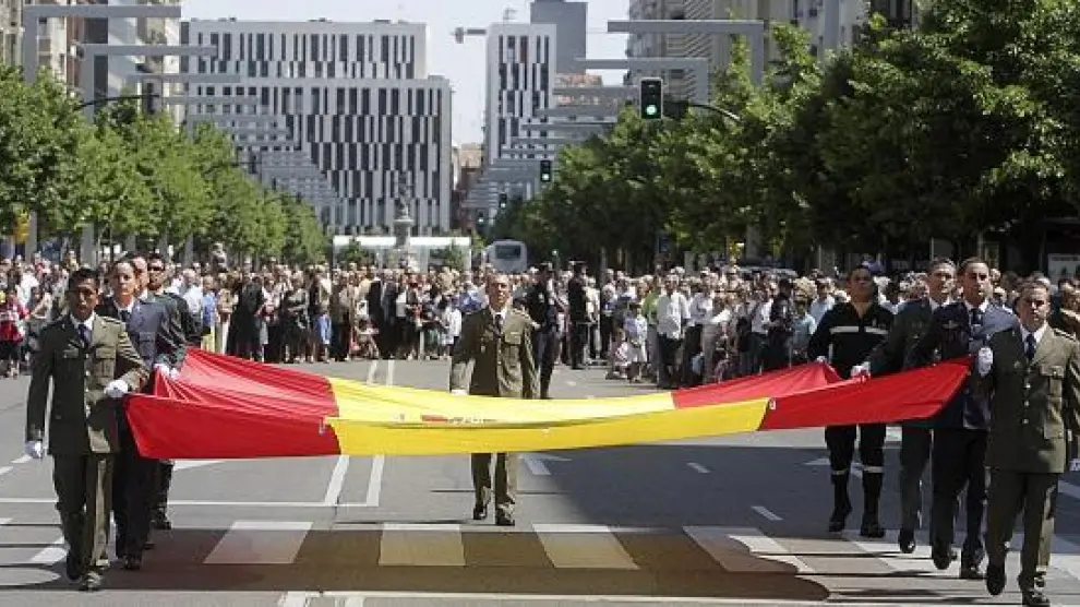 Los soldados portan la gran bandera que el Ministerio de Defensa donó al Ayuntamiento en 2008.