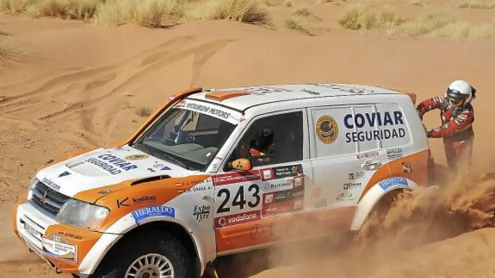 Miguel Grasa se esfuerza por ayudar a sacar el coche de un arenal en el desierto.
