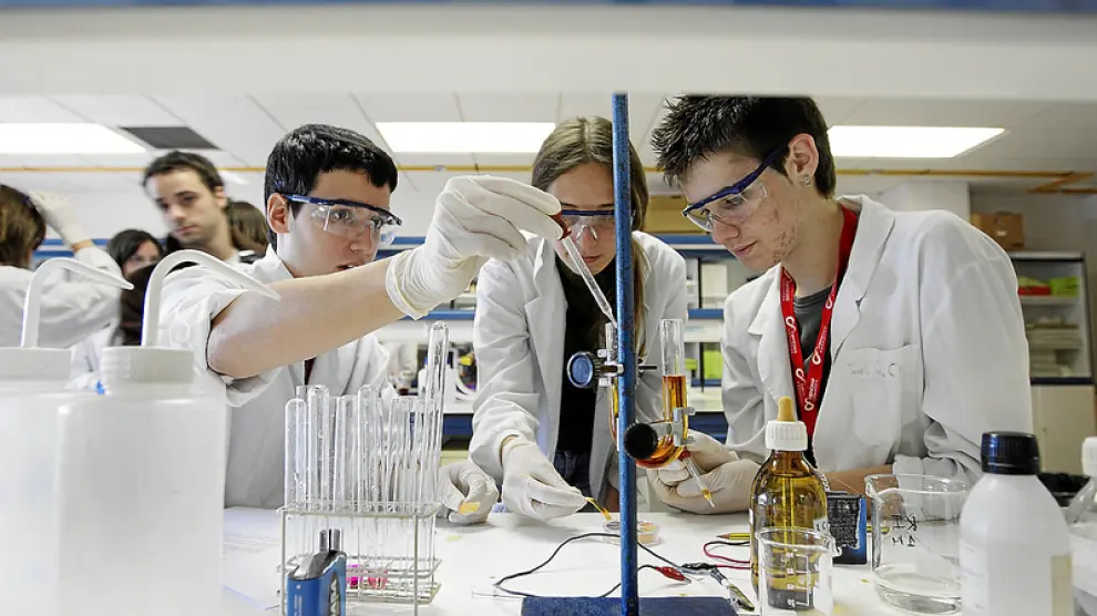 Tres alumnos de bachillerato experimentan en un laboratorio de la Facultad de Ciencias.