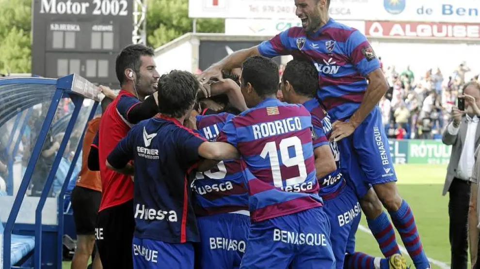 Mikel Rico, a la derecha, se sube a la piña que formaron sus compañeros para celebrar el gol de Luis Helguera al Cádiz.