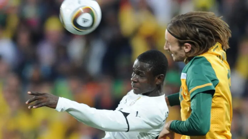 El defensa de Ghana, Jonathan Mensah (izquierda) busca el balón ante el australiano Josh Kennedy