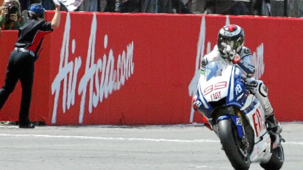 El piloto español de Yamaha Jorge Lorenzo entra victorioso en la meta del circuito de Silverstone.