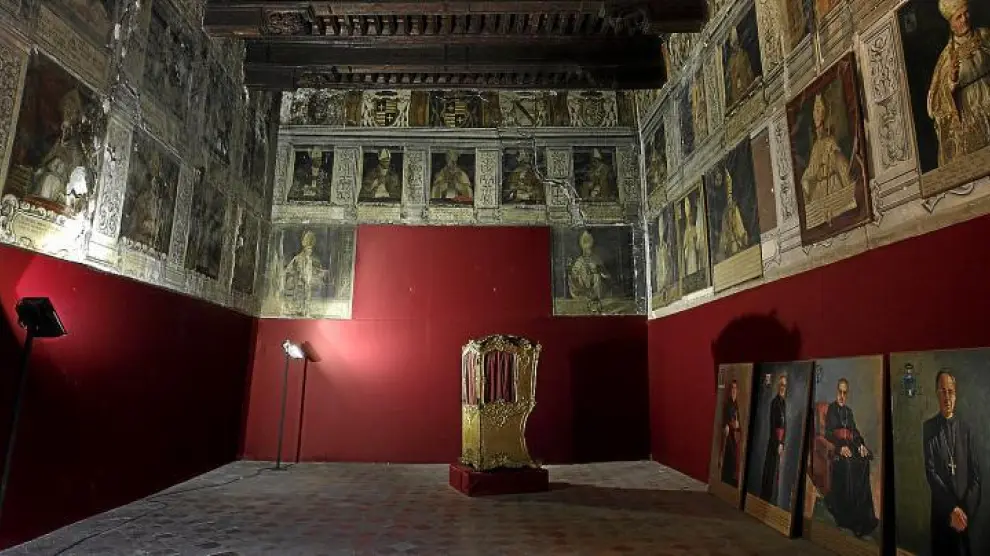 Interior del Salón de Obispos del palacio arzobispal, con el artesonado restaurado y las pinturas deterioradas.