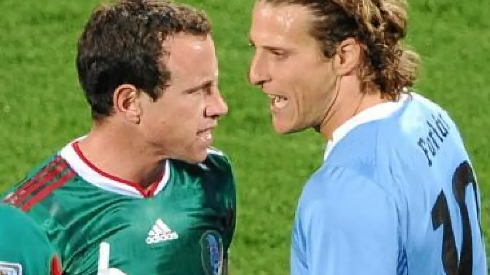 Diego Forlán se encara con un rival.