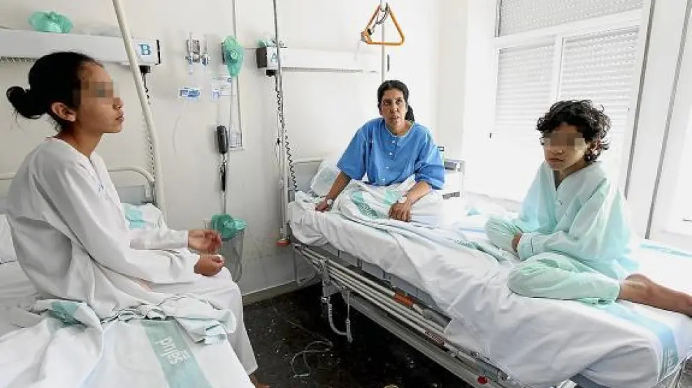 Zulica, en el centro, con dos hijas, en la habitación el hospital donde se recuperan de la intoxicación.