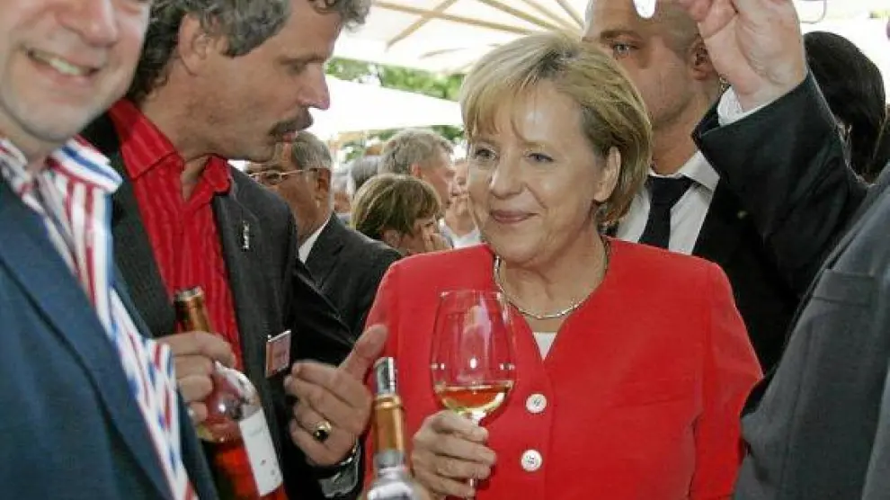Merkel, en el centro de la imagen, junto al importador de Bodegas Pirineos, Hein Heinz (izquierda).