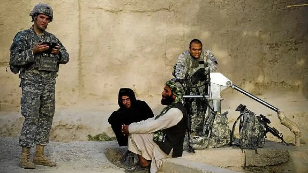 Dos soldados estadounidenses charlan con dos civiles afganos de la provincia de Kandahar.