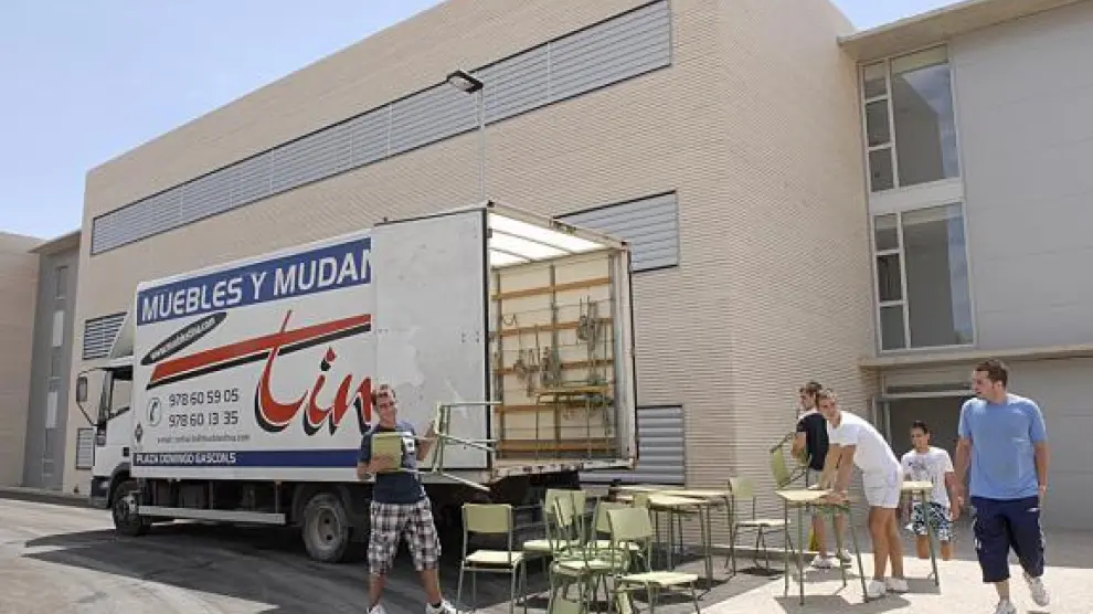 Los operarios de la mudanza transportan mobiliario al nuevo centro.