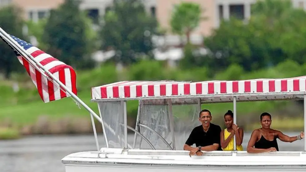 Obama, la primera dama Michelle y su hija Sasha recorrieron ayer en barco la bahía de St. Andrews, en Florida.
