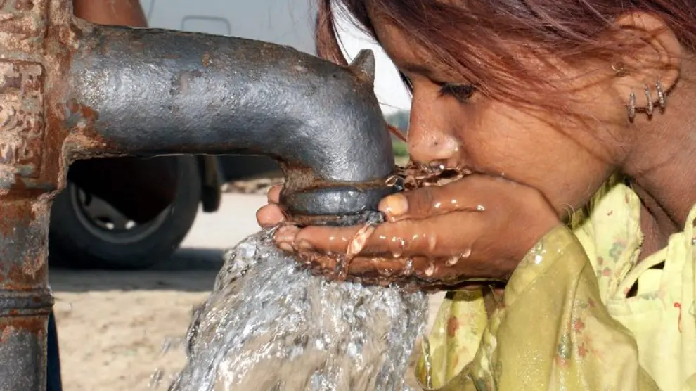 Una niña bebe agua en un campo de acogida a los afectados por las inundaciones