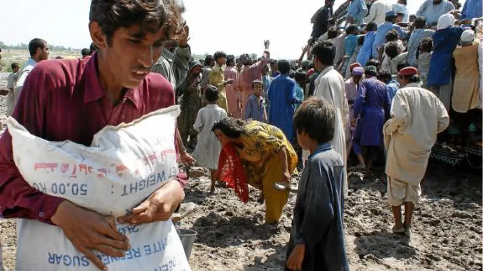 Víctimas de las inundaciones recogen la ayuda humanitaria en un campo de refugiados en Sukkur.