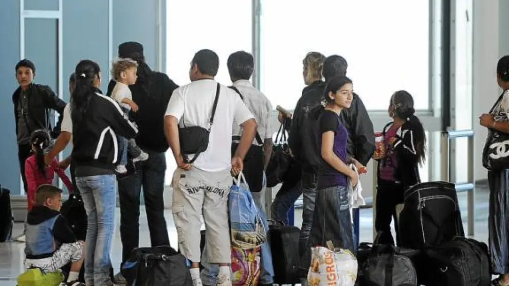 Un grupo de gitanos esperan para ser embarcados en un avión rumbo a Bucarest, ayer en Lyon.