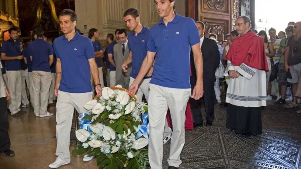 Ponzio, Jorge López y Gabi portan el centro de flores ofrecido a la Virgen del Pilar.