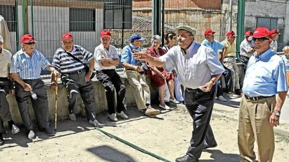 Un grupo de pensionistas juegan a la petanca.