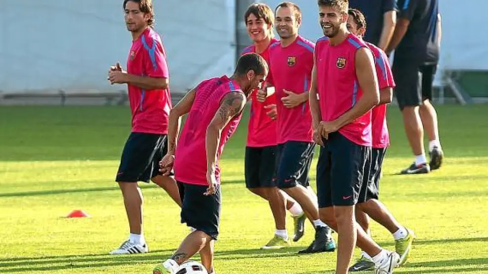 Dani Alves juega con el balón, durante un entrenamiento del Barcelona.