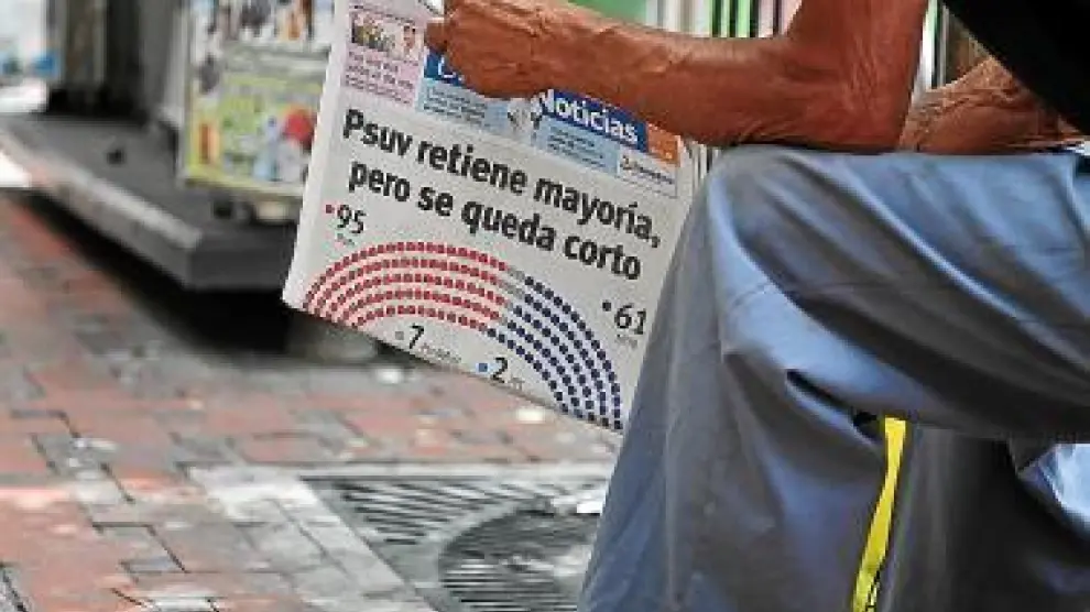 Un limpiabotas lee un periódico, ayer en Caracas.